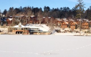 View of Lodges at Cresthaven from middle of frozen lake in winter.