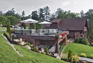 Patio area with umbrellas with hot tub area below.