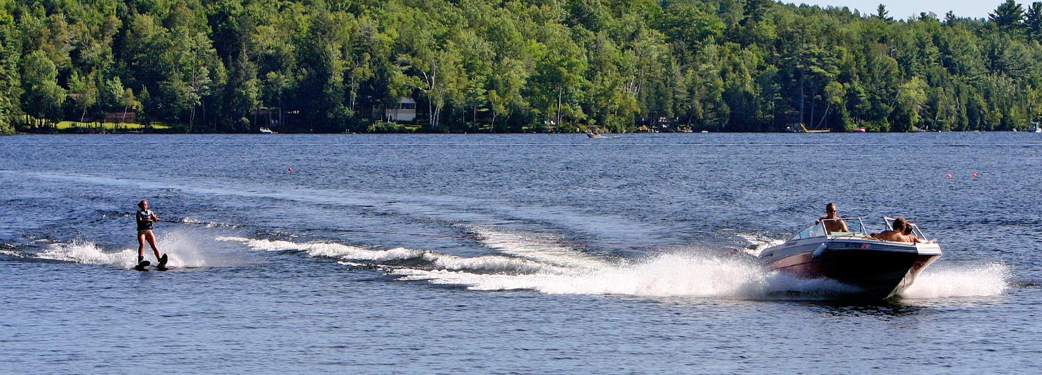 Ski boat on Lake George pulling water skier.