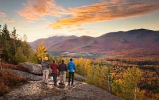 Group of people taking in beautiful Adirondack vista while hiking in autumn.