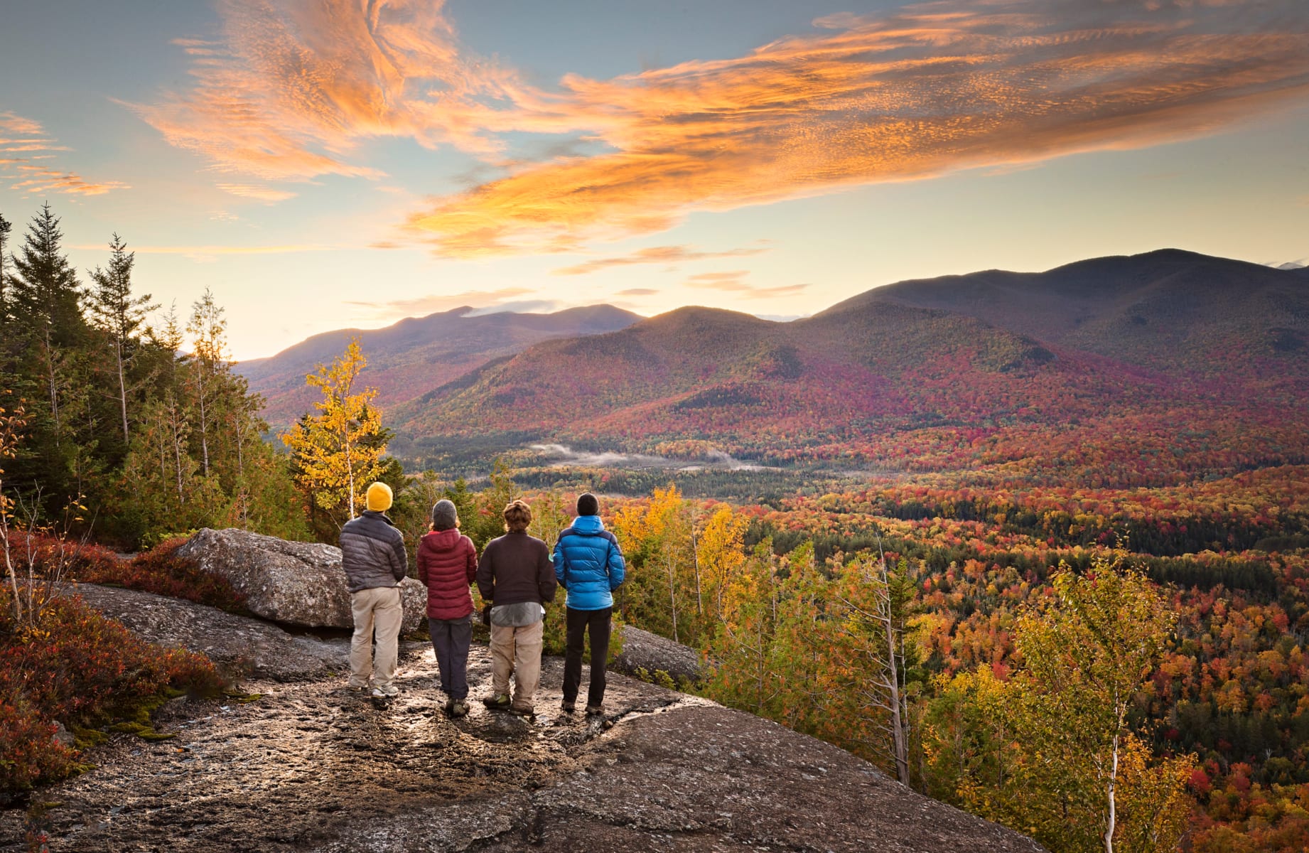 Group of people taking in beautiful Adirondack vista while hiking in autumn.