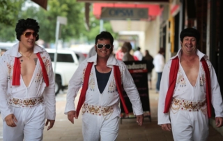 Three Elvis impersonators on a sidewalk