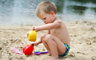 boy playing with sand on a beach