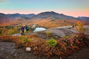 A small family gazing into the horizon while hiking in the Adirondacks.