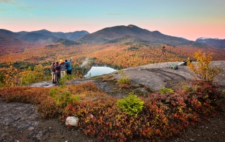 A small family gazing into the horizon while hiking in the Adirondacks.