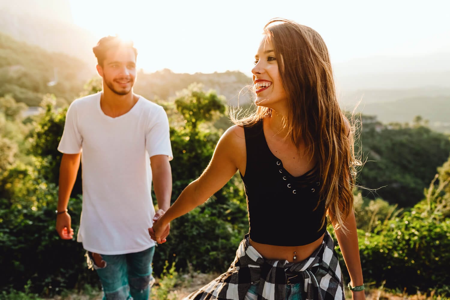 An attractive young couple walks along a hiking trail in Lake George, NY.