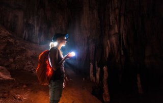 Photo of person with a flashlight in the caves near Lake George
