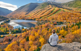 Photo of a person enjoying panoramic views of Lake George fall foliage