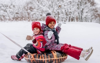 Kids enjoying snow tubing during an Adirondacks winter getaway in Lake George