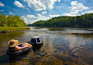 person tubing down a river near Lake George